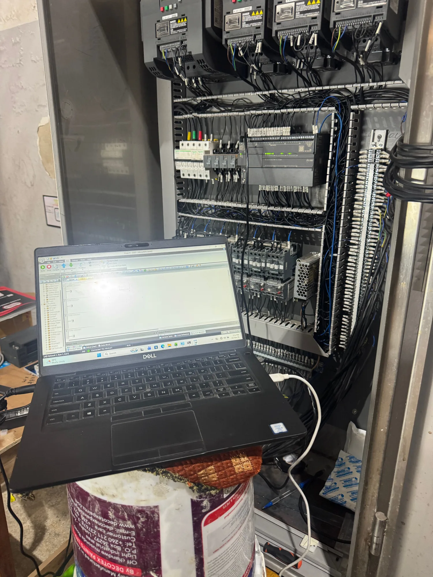 PLC commissioning on site with a laptop connected to a control panel
