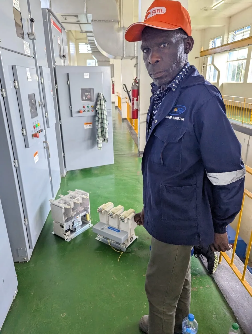 HCS technician in a client plant room beside switchgear