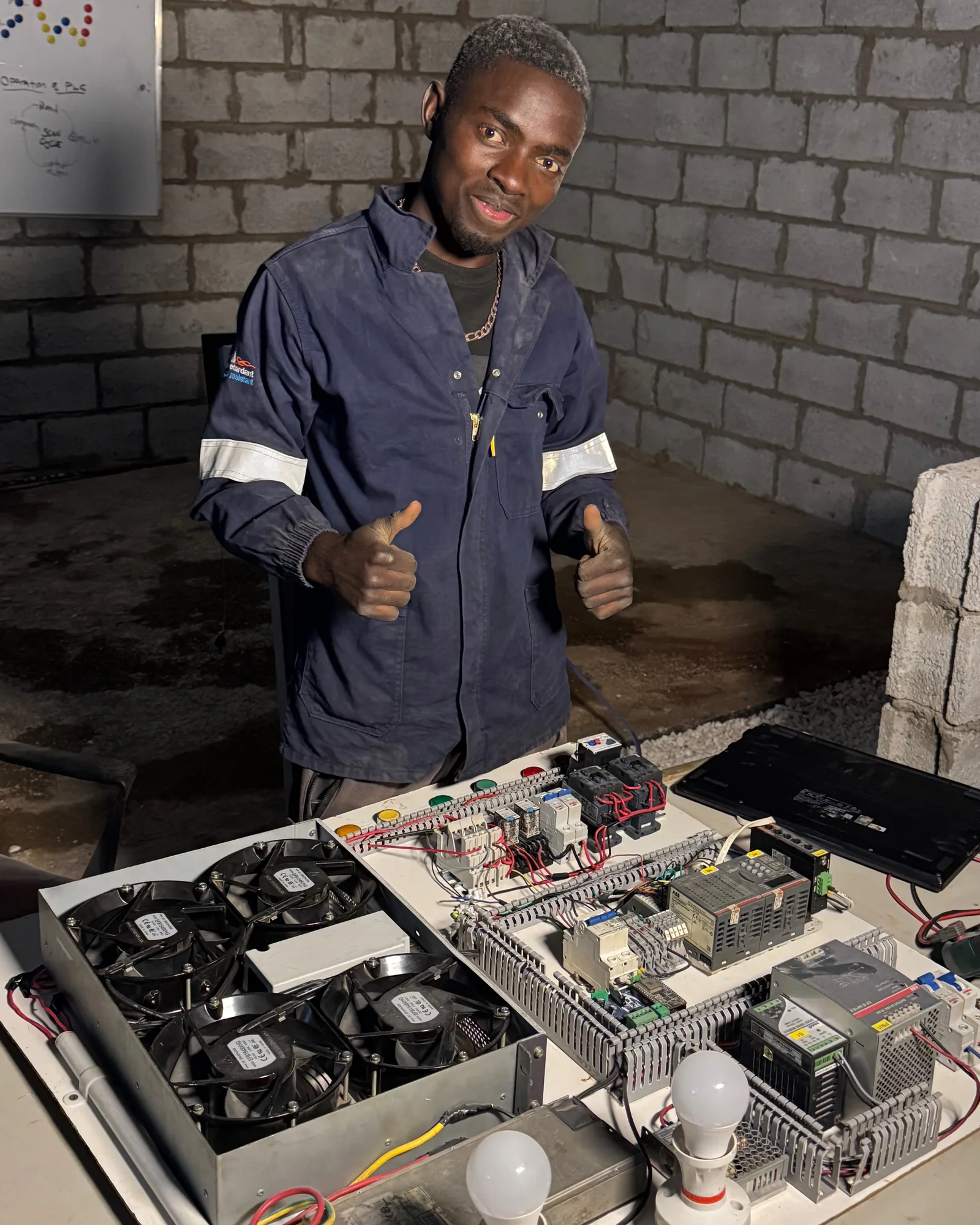 Technician behind a bench-built PLC panel